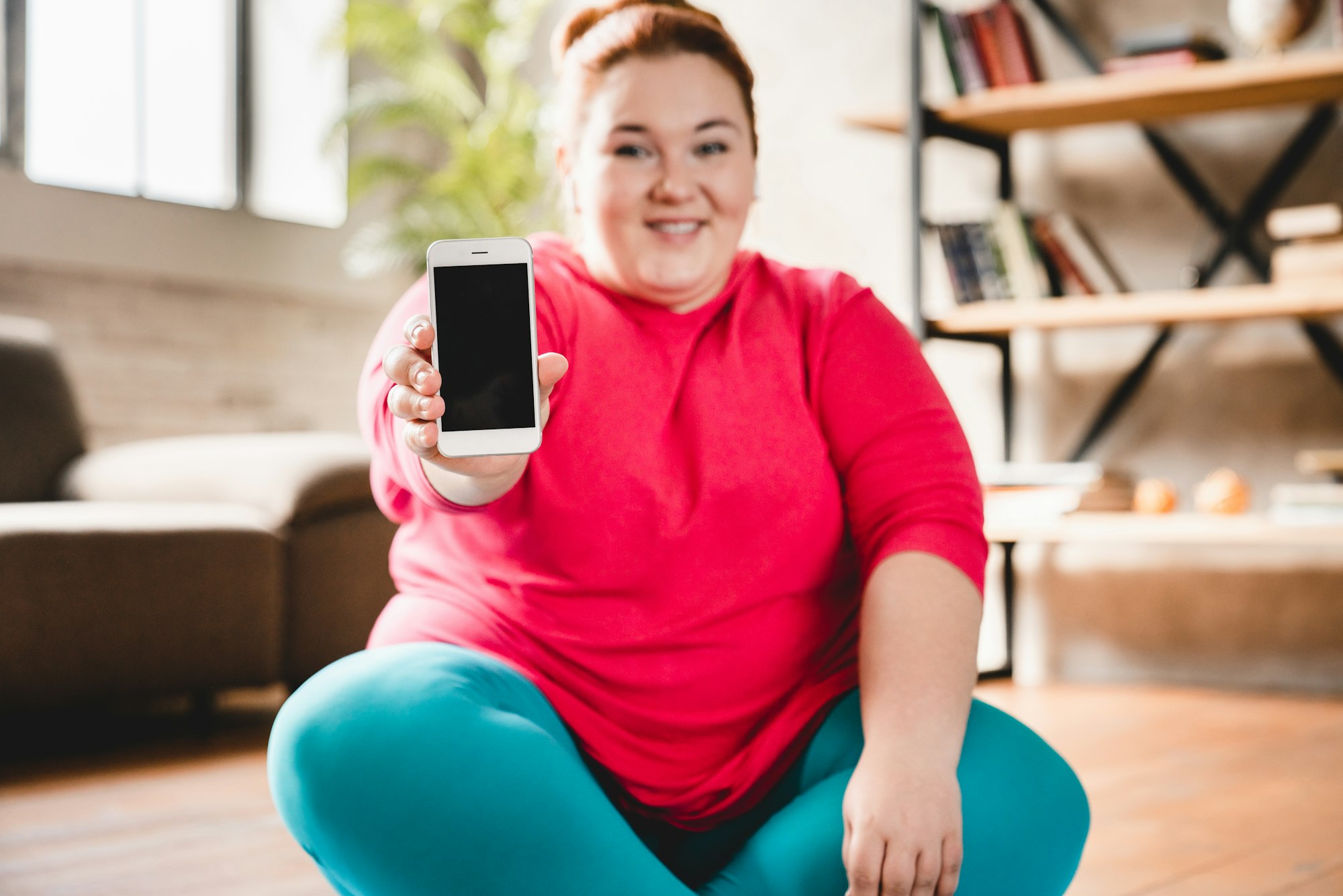 Fat obese caucasian plus size woman showing blank phone`s screen