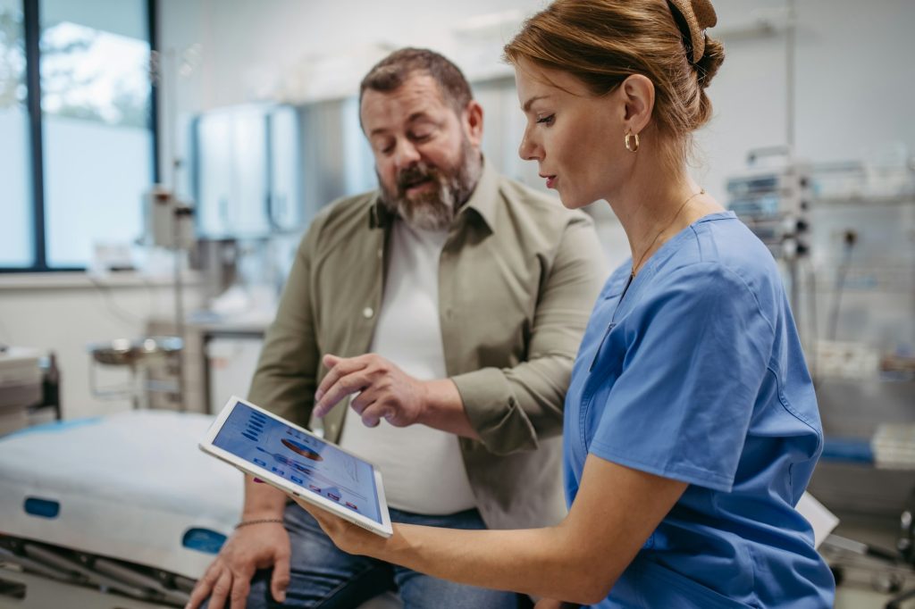 Female doctor consulting with overweight patient, discussing test result in doctor office. Obesity